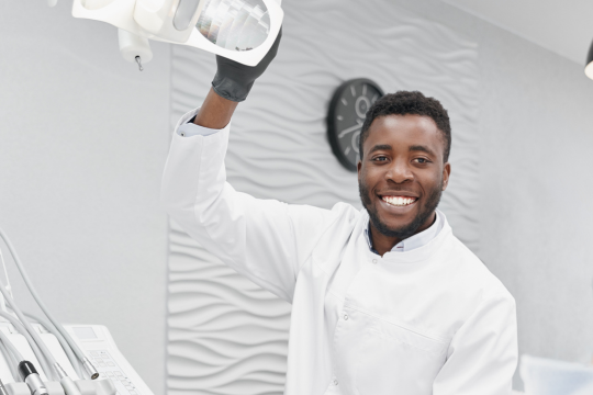 Adult male dentist in white uniform.