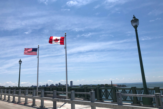 American and Canadian flags blowing side by side at the Peace Bridge.